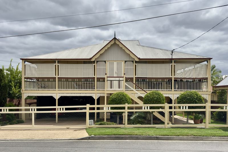 Large timber Queenslander with wide verandahs and a white picket fence in Graceville, Brisbane